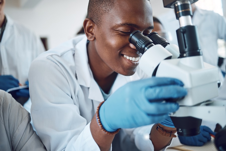 Young doctor looking through a microscope in Africa Young doctor looking through a microscope in Africa
